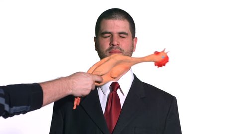 Businessman gets hit with rubber chicken. Slow motion. 