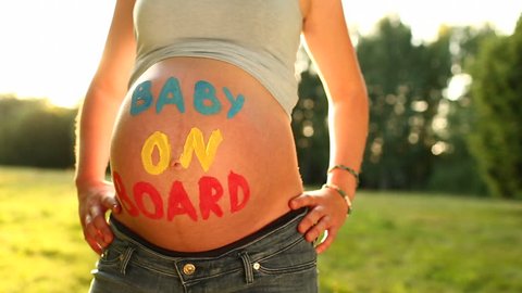 Pregnant woman with "baby on board" written on baby belly