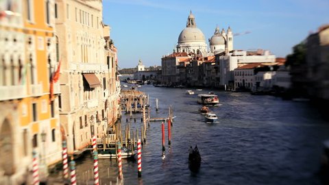 Soft focus view of water vessels traveling the Grand Canal near a cathedral and beautiful architecture in Venice, Italy