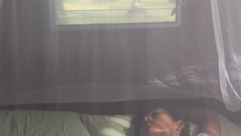woman sleeping under a mosquito net