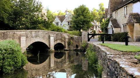 Scenic view of a family of ducks passing under a stone footbridge in the peaceful rural  town of Castle Combe Village in Wiltshire, United Kingdom