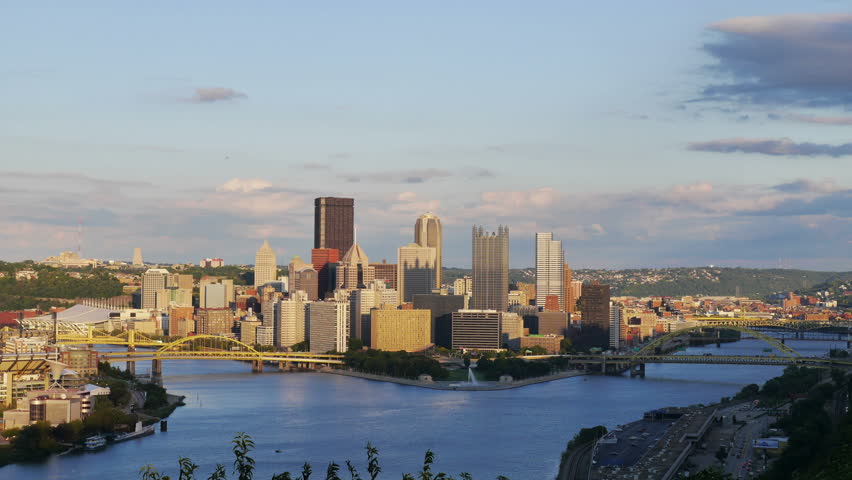 A day-to-night time lapse shot of the Pittsburgh city skyline as seen from the