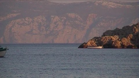 Dusk, fishing boat returns to port in Halki