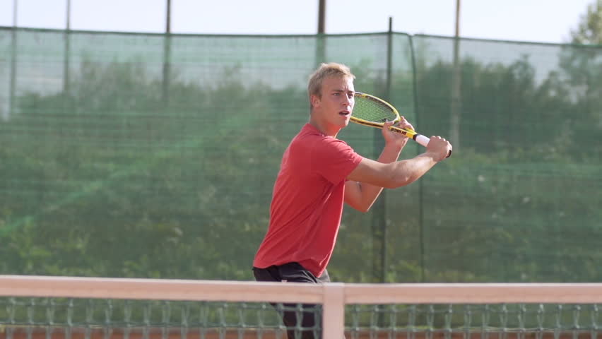 Slow Motion Shot Of An Athletic Tennis Player Hitting Tennis Ball With Tennis