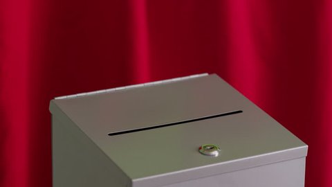 Hand puts vote into ballot box