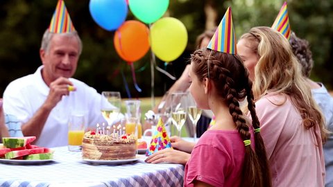 Family celebrating the birthday of a girl in the garden