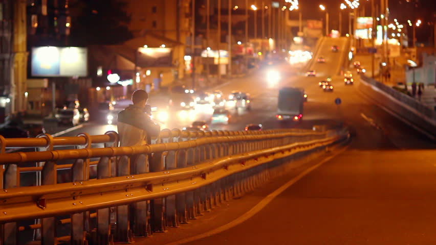 Night city cameraman shooting traffic on bridge road junction