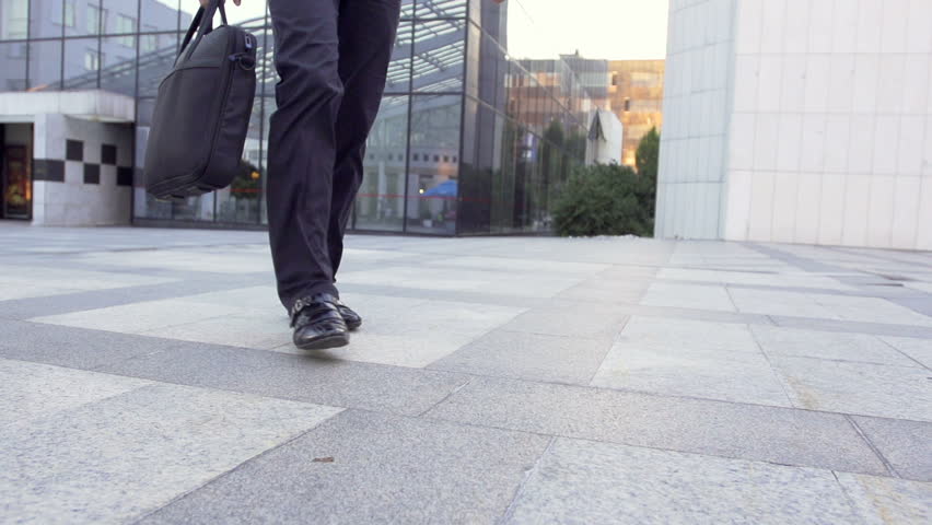 Slow Motion Shot Of A Male Legs Walking Through Business Area. Casually Dressed