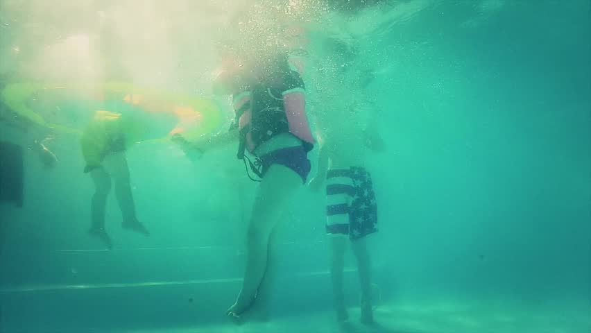 Kids playing at the swimming pool underwater shot