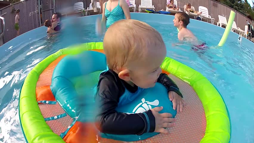 A baby in a flotation device at the pool