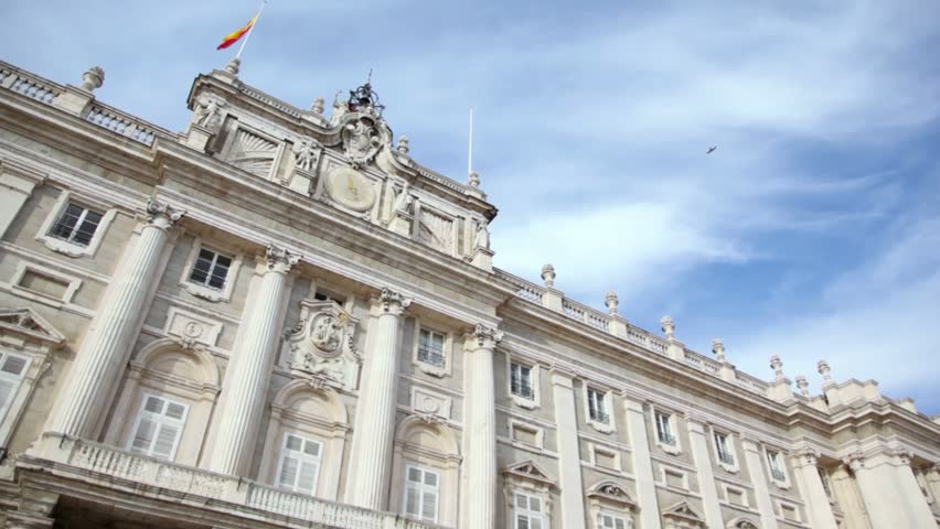 Spanish flag flutters on Congress of Deputies building at sunny day in Madrid, Spain.