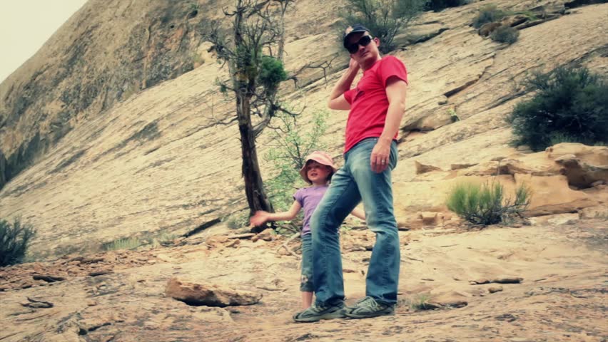 A father teaching his daughter to climb rocks in southern utah