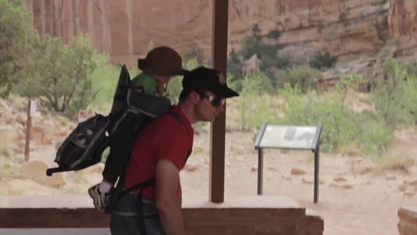 A father hiking with his baby in a child carrier hiking backpack in Capitol Reef