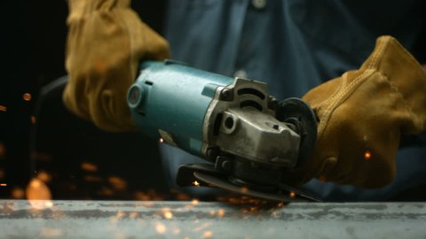 Worker using industrial grinder, slow motion