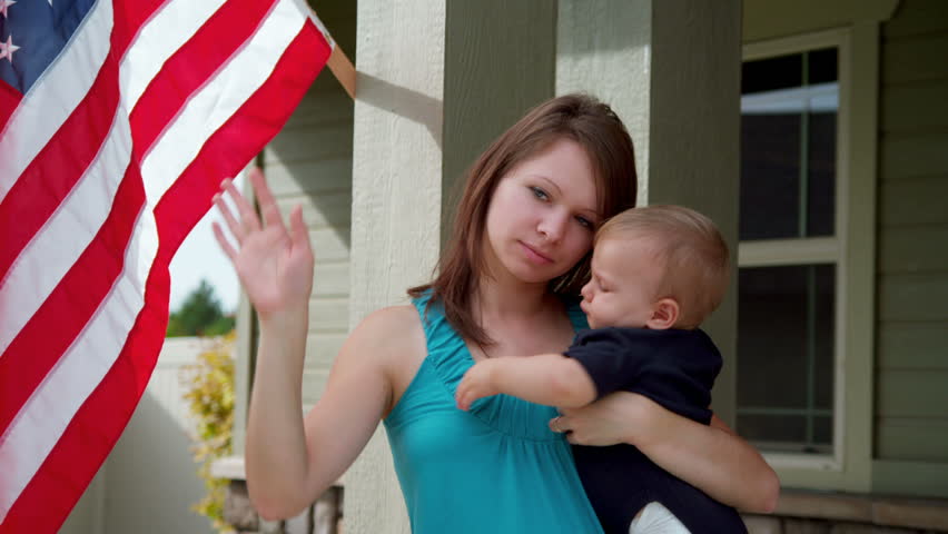 Young woman and baby say goodbye to soldier