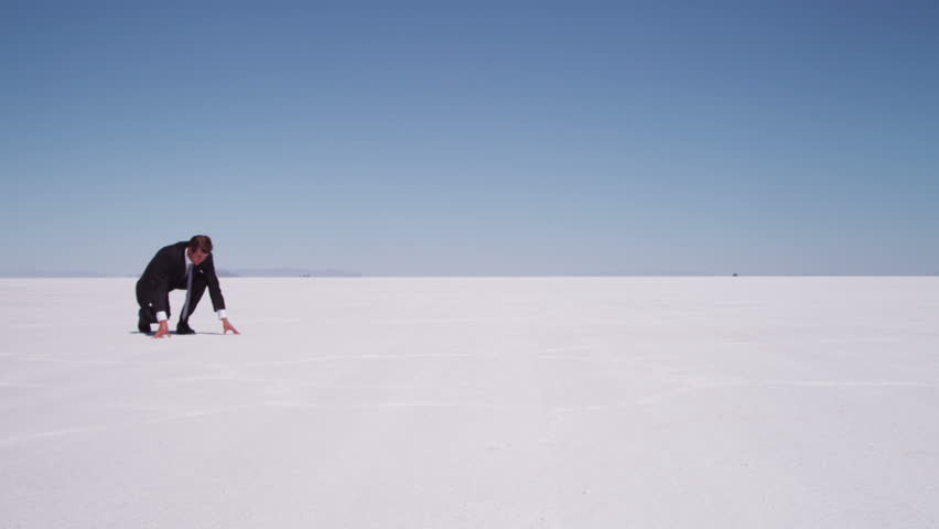 Businessman running at salt flat, slow motion
