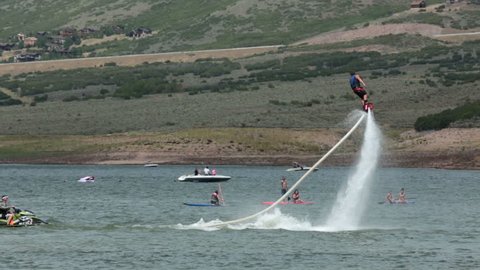 PARK CITY UTAH AUG 2013: New invented extreme water sport. Fly Board on mountain lake slow motion. Flyboard is a aerial machine for a personal watercraft which allows propulsion underwater and in air.