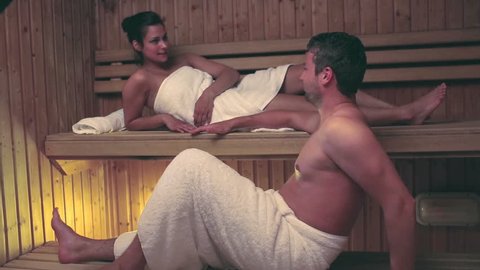 Couple relaxing and chatting together in a sauna at the hotel spa