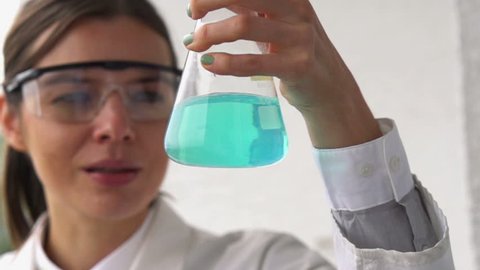 Female scientist mixing chemicals in erlenmeyer flask
