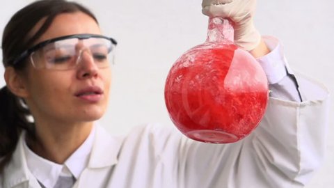 Female scientist mixing chemicals in flask
