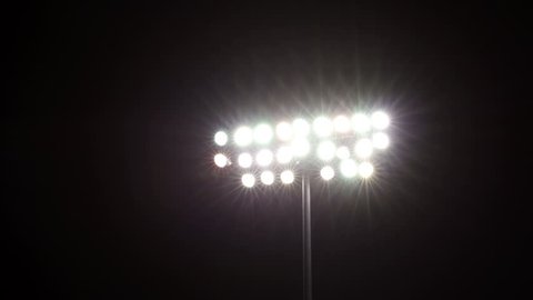 Isolated shot of stadium flood lights turning on a black sky background