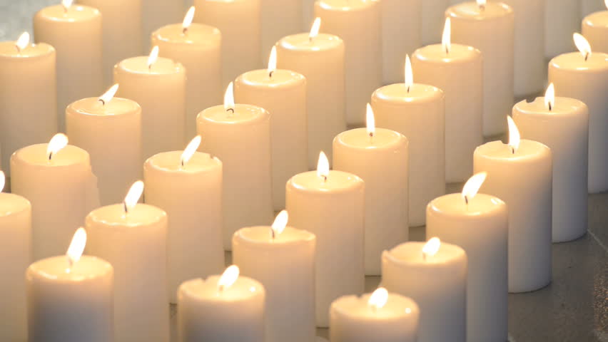 Edited Dolly Shot Of Multiple White Candles Burning With Bright Candle Light.