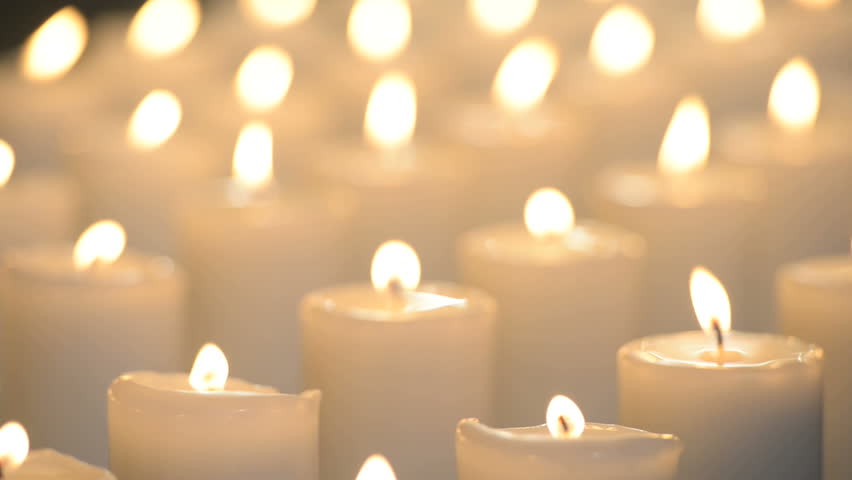 Edited Shot Of White Candles Being Lit Up By A Person And Then Glowing With Soft
