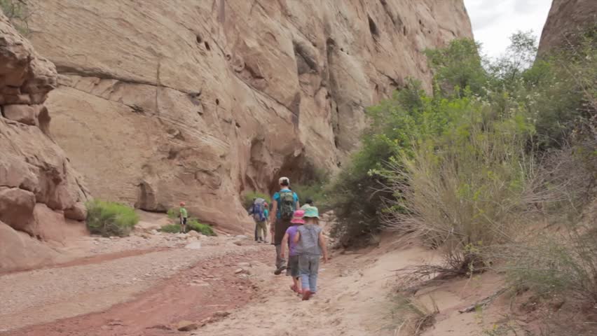 A family hiking through a desert slot canyon in Capitol Reef National Park