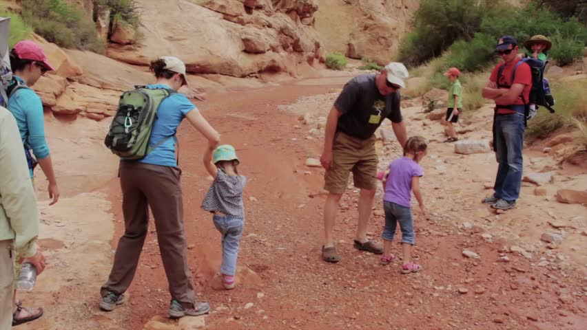 A family hiking through a desert slot canyon in Capitol Reef National Park