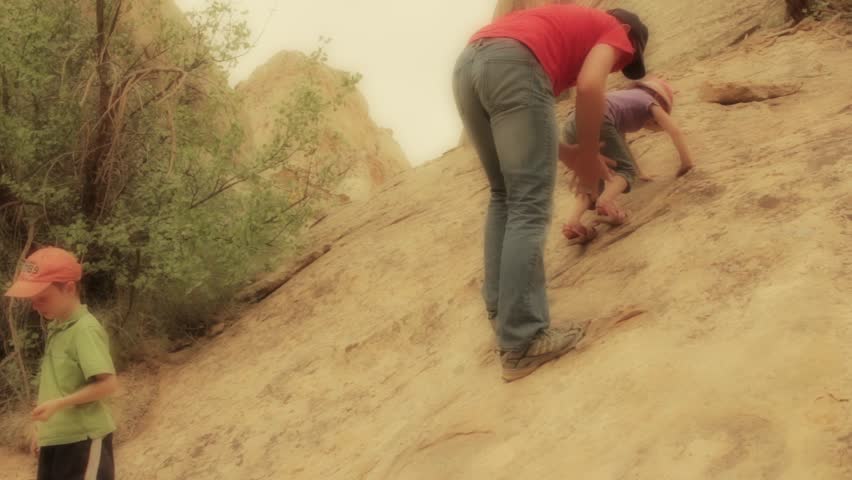A father teaching his daughter how to climb on desert sandstone