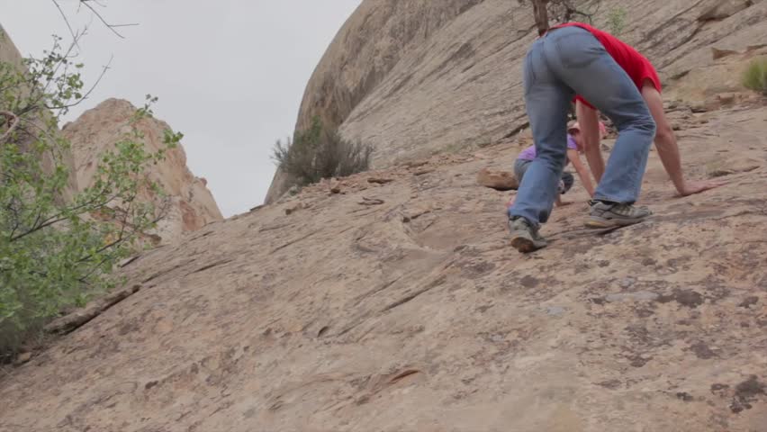 A father teaching his daughter how to climb on desert sandstone