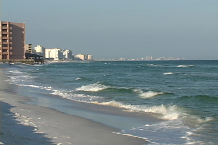 Waves break on the beach at the resort city of Destin, Florida with condominiums and hotels in the background.