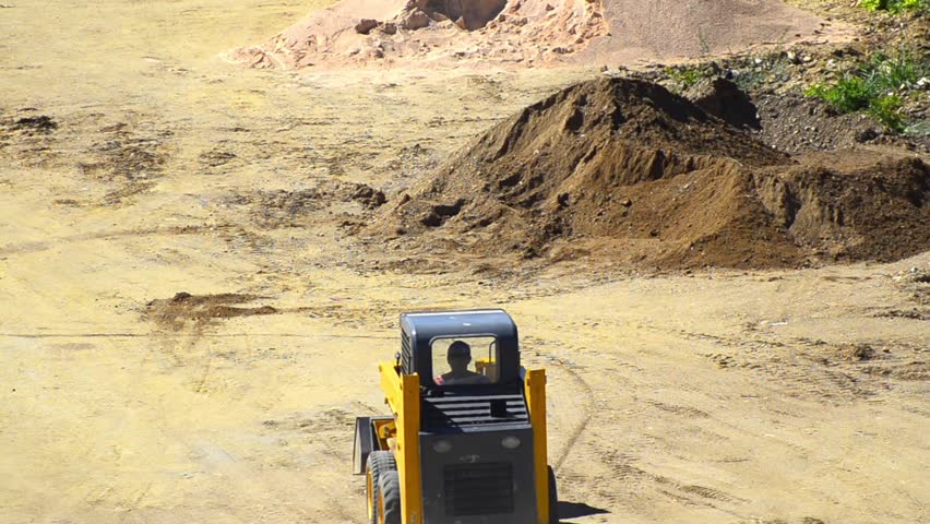 Bulldozer Pushing Sand - Stock Video. View of a bulldozer pushing sand as it