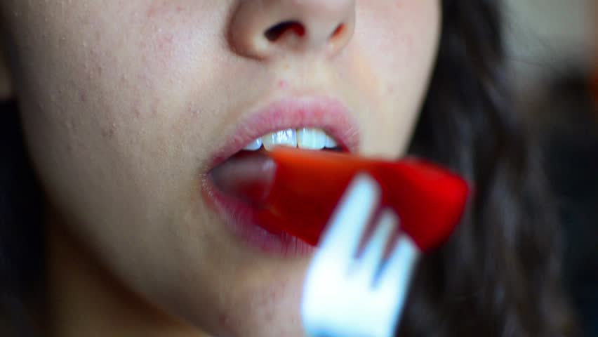 Close up of beautiful teen mouth eating tomato - Stock Video. HD: Macro of girl