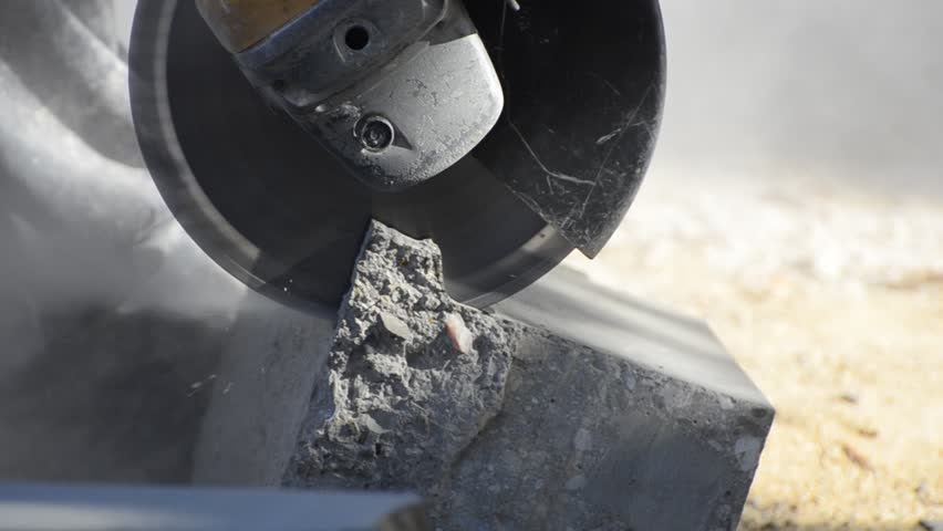 angle grinder cutting concrete block for road construction - Stock Video. A