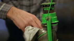 Elderly man cleaning an old petroleum lamp in a dark cellar. Close up. High definition video. - Powered by Shutterstock - Get 15% off with code: PIKWIZARD15