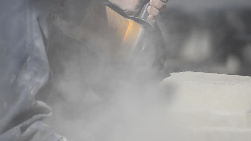 Worker using industrial grinder- Stock Video. Dramatic dust polluting atmosphere