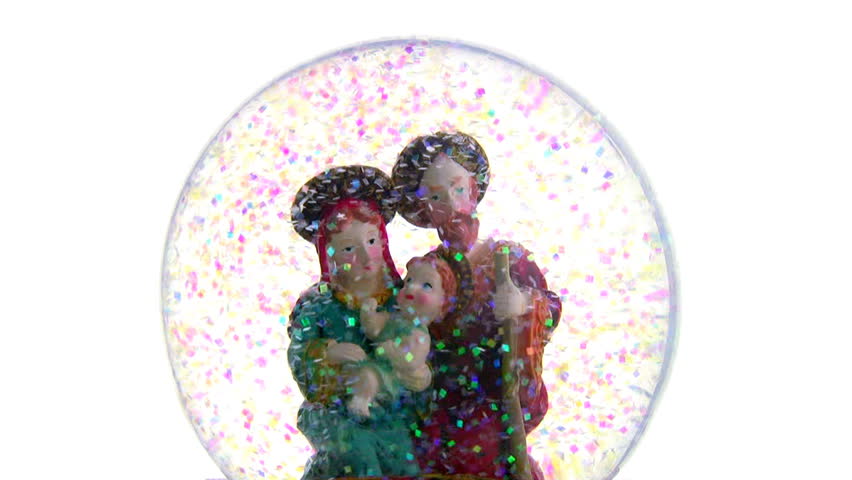 Joseph and Mary with baby Jesus in her arms. Glass ball with toy figures on a