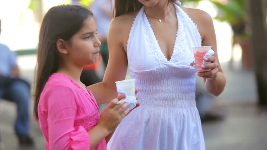 A young family eats ice cream on the street