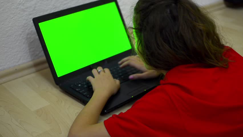 Girl  using laptop compute, green chrome key - Stock Video. Dolly zoom shoot of