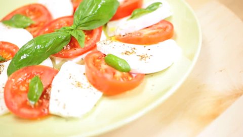 Close up view of a fresh delicious Italian caprese salad with basil leaves