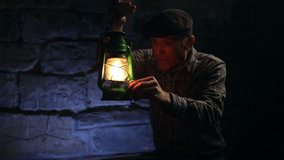 Elderly man lighting an old oil lamp in darkness and leaving the frame. - Powered by Shutterstock - Get 15% off with code: PIKWIZARD15