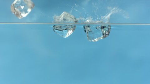Ice cubes dropping into water slow motion