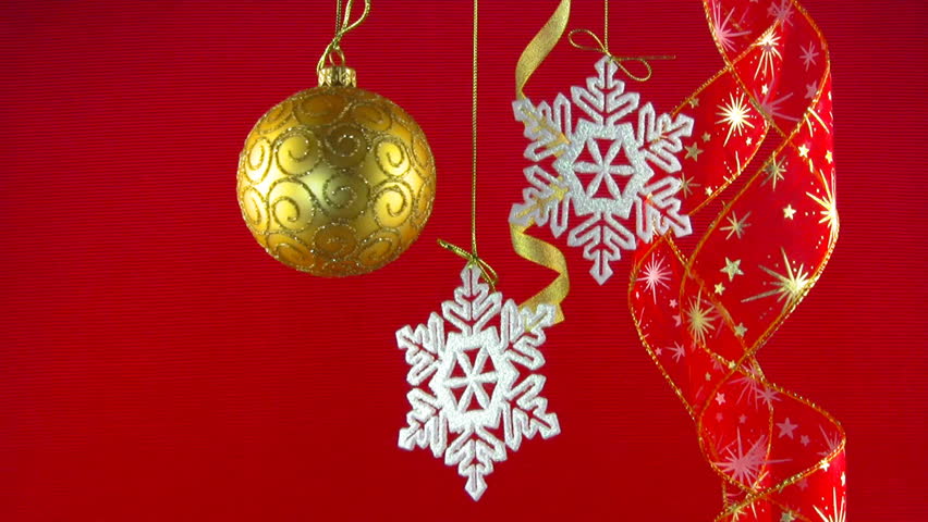 Golden ball, white snowflakes and red ribbons hanging on the gold thread on a
