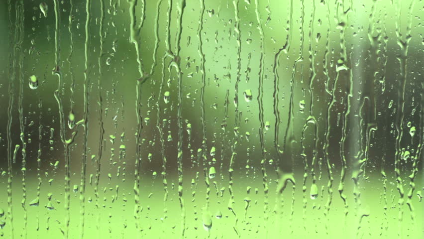 Raindrops on a window, with a lush green background.  HD 1080p