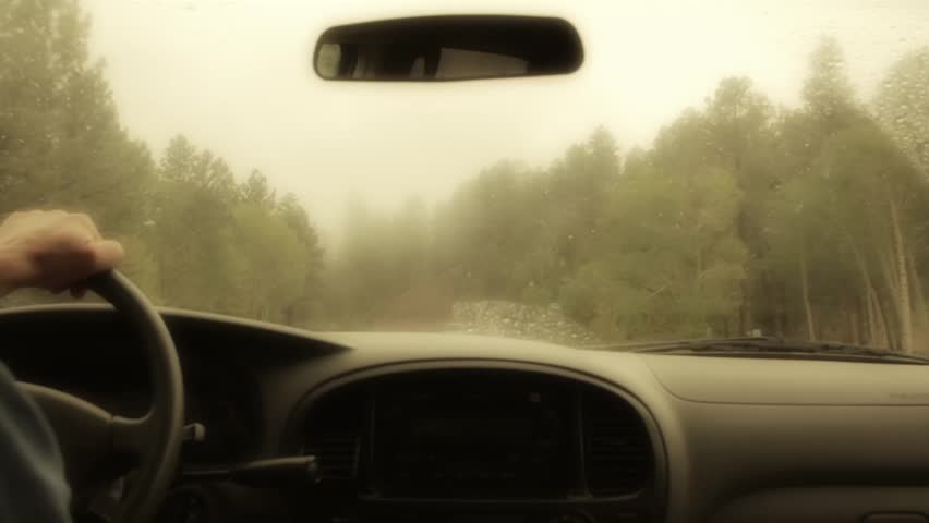 Driving up a mountain road in thick fog and rain
