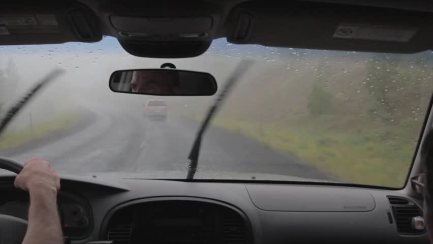 Driving up a mountain road in thick fog and rain