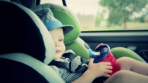 A toddler in his car seat in the car