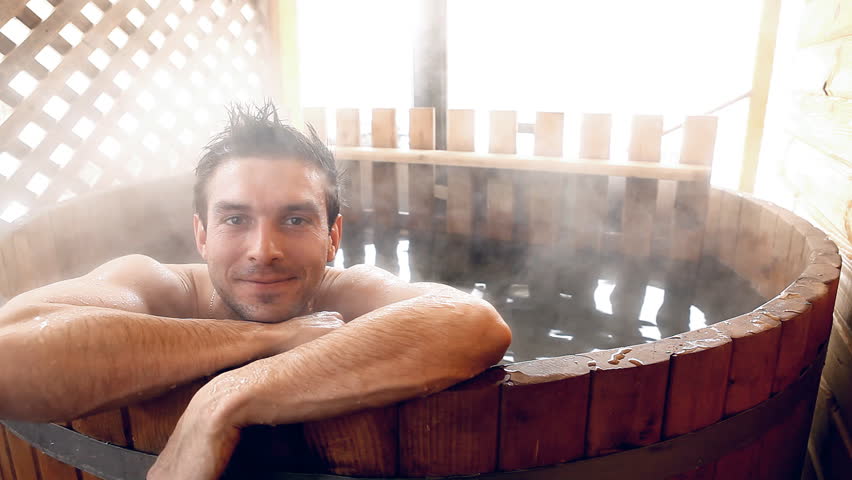 Man sitting in hot water outdoor at winter