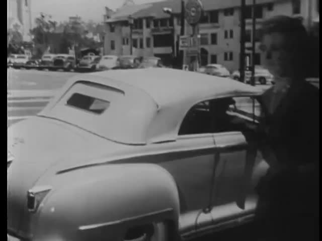 Vintage cars following each other on city street, Los Angeles, California